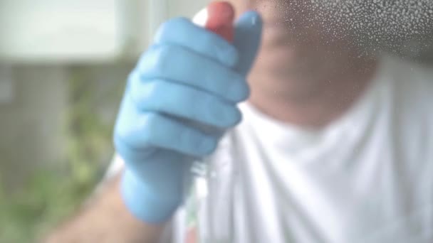 Mann Wäscht Und Reinigt Fenster Hause Mit Reinigungsspray Und Desinfektionsschaum — Stockvideo