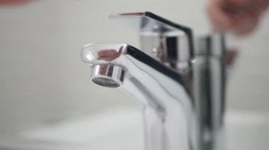 Banyodaki lavabodan suyu açıp ellerini yıkamak..