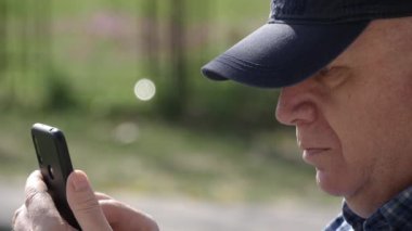 Sıkıcı ve üzgün kişi cep telefonundan mesaj yolluyor ve okuyor. Cep Telefonu Bağlantısını Kullanan Adam Metni.