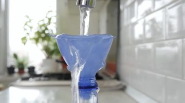 Plastik şişeyi taze suyla doldurmak Plastik Huni kullanmak. Bir alıcıda su rezervi yapmak. Su Ekonomisi kavramı.