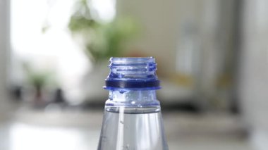 Plastik şişe damlasını suyla dolduruyorum. Bir alıcıda su rezervi yapmak. Su ekonomisi konsepti. Damlayan su.