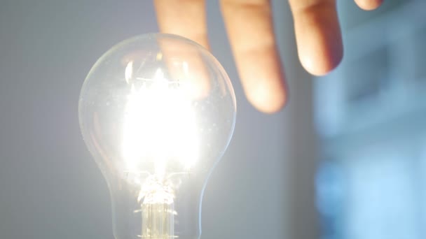 手在Socket旋转一个带灯的灯泡 关掉房间里的灯 利用灯具照明节省家居能源 — 图库视频影像