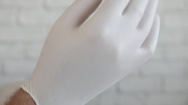 Doktor Sterilize Koruyucu Eldivenleri Tıbbi Müdahale İçin Hazırlıyor. Hemşire Eldiven Giyiyor..