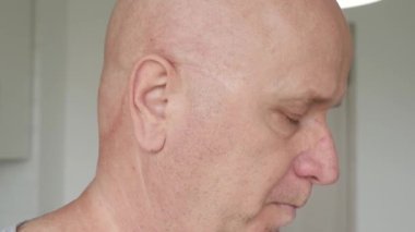 Hastanedeki yaşlı insan kendini hasta hissediyor ve ilaçlarını suyla alıyor. Kalp sorunu olan bir adam kalp hastalığı için ilaç alıyor..