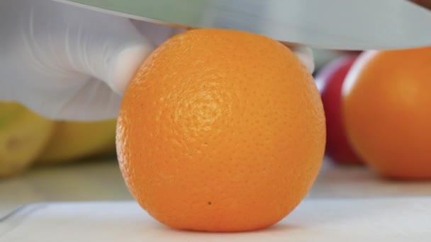 男人在厨房里用刀把多汁的橙子切成两半 美味的素食小吃 令人耳目一新的清凉早餐 — 图库视频影像