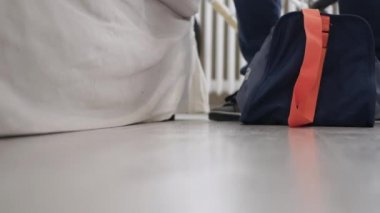 Spor çantasını yerden alıp odayı terk eden bir adamla çekim yapmak..