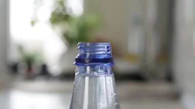 Plastik şişe damlasını suyla dolduruyorum. Bir alıcıda su rezervi yapmak. Su ekonomisi konsepti. Damlayan su.