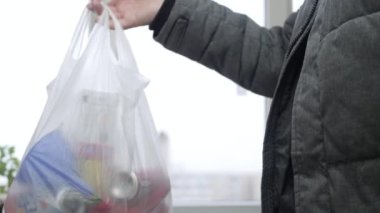 Alıcı dükkandan eve dönüyor ve alışveriş fişini kontrol ediyor. Bakkaldan Adam Masrafları Kontrol Ediyor. Yiyecek için Mali Bütçe Hesaplayan Yaşlı Kişi. Aile Bütçe Ekonomisi. Mali Kriz.