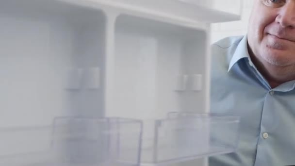 Голодный Человек Открывающий Пустую Дверь Холодильника Выглядит Изумленным Разочарованным Еде — стоковое видео