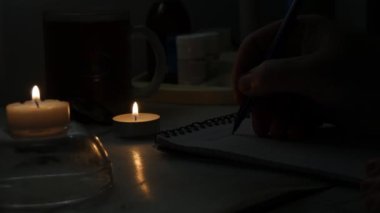 Karanlık Bir Odada Yanlışlıkla Güç Yanlışlığı Zamanı 'nda Işıklı Mum ile aydınlatılmış Kağıt Bir Kağıt üzerinde Bir Kalem ile Yazan Adam.