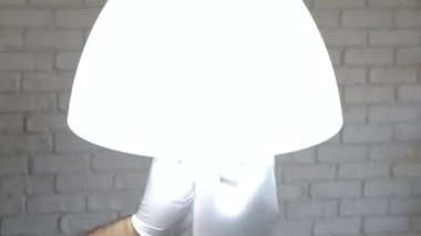 Led Ampulü Lambadan Çıkarıp Değiştiren Adam. Evde, Led Technology Tasarruf Enerjisi ile Modern Aydınlanma kullanan bir kişi.