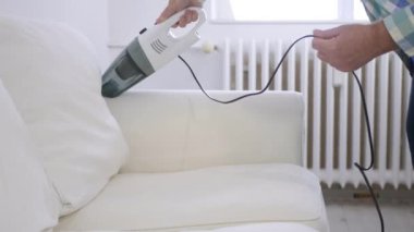 Ev Etkinlikleri 'nde Elektrikli süpürge kullanan adam. Bir Aspiratörle Toz 'dan Kanepeyi Temizleyen Bir Kişi.