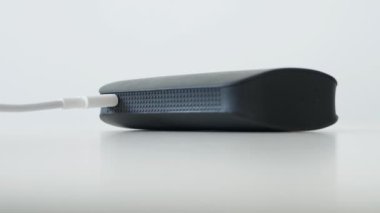 Cep telefonları için şarj edilebilir bir enerji bankasını elektrik şarjından sökmek. Şarj cihazından taşınabilir bir pil çıkarılıyor.