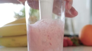 Soğuk milkshake 'i çilek ve taze sütle karıştırmak, sağlıklı enerji içeceği. Blender 'la Ev Yapımı Meyve Smoothie yapıyorum.