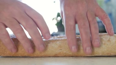 İki yarıya bölünmüş bir Aç Kişi ile Çekim Taze ve Lezzetli Bir Ekmek. Bir Pastanede Ekmek Sunumu.