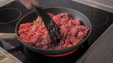 Chef stir and fry minced meat in a frying pan. Frying minced meat in a pan, close-up.