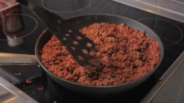 Chef stir and fry minced meat in a frying pan. Frying minced meat in a pan, close-up.