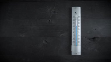 İklim değişikliği. Siyah ahşap masadaki termometre sıcaklığın arttığını gösteriyor. Küresel ısınmayı kavra