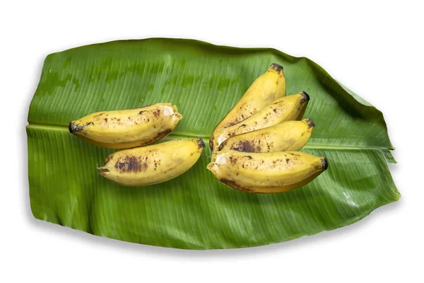 Yeşil muz yaprağının tepesinde sarı muz yığını.