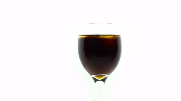 Eiswürfel fällt in ein isoliertes Weinglas auf weißem Hintergrund