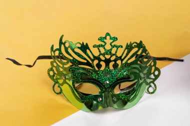 Sarı-beyaz arka planda renkli karnaval maskesi.