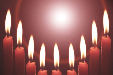 Karanlıkta yanan kırmızı bir mum ve bir ışık..