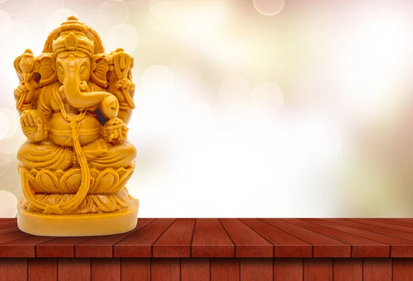 ヒンズー教の神ガネーシャの木のテーブルの上にぼやけたボケの背景 — ストック写真