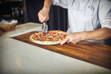 Büyük bir pizza aşçı tutar .