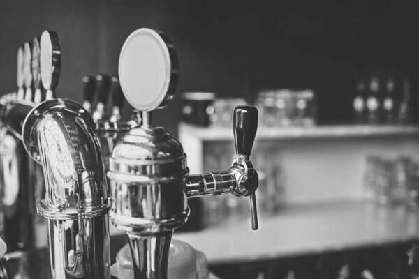 lose-up of barman hand at beer tap pouring a draught lager beer