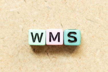 Tahta zemin üzerinde WMS (depo yönetim sisteminin kısaltması) ile renk alfabesi harf bloğu