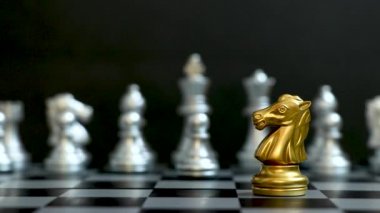 Altın at satranç taşı siyah arka planda gümüş takımı yendi ve kazandı (Şirket stratejisi, iş zaferi veya karar kavramı)