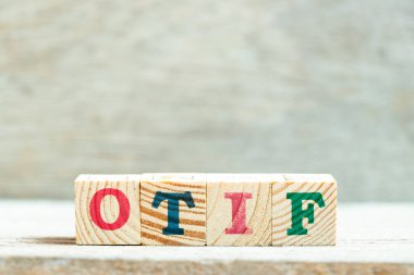 Tahta zemin üzerinde kelime OTIF (Tam Zamanla On 'un kısaltması) harfli alfabe bloğu