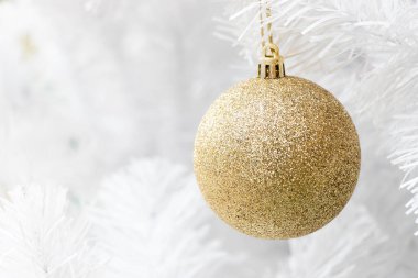 Noel ağacı arkaplanının beyaz dalında altın renkli top (Noel ve Yeni Yıl Festivali Dekorasyonu)