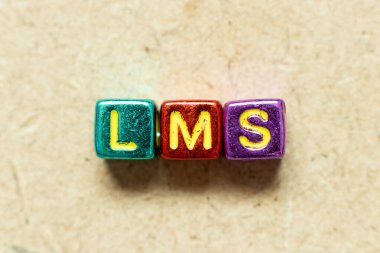Tahta zemin üzerinde LMS (Öğrenme yönetim sisteminin kısaltması) kelimesindeki metalik renk alfabesi harf bloğu