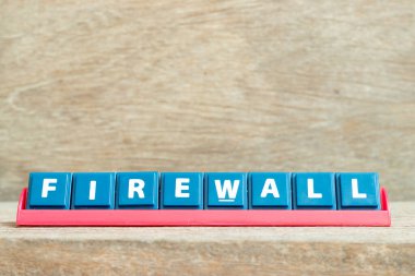 Ahşap arka planda kırmızı rafta kelime güvenlik duvarı olan döşeme alfabesi harfi