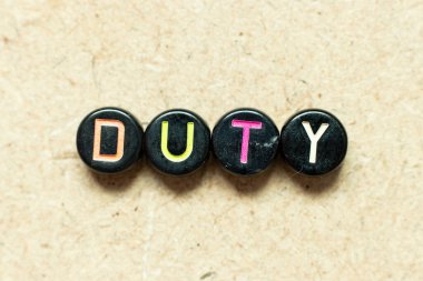 Ahşap arkaplanda kelime görevinde siyah renk yuvarlak alfabe harf bloğu