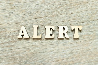 Ahşap arka plan üzerinde kelime uyarı mektubunda alfabesi