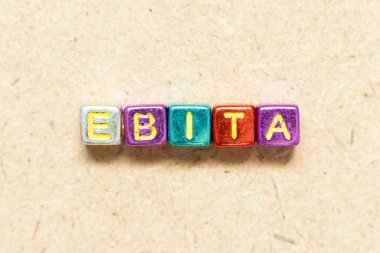 Tahta zemin üzerinde EBITA (faizden önce kazancın kısaltması, vergiler ve amortisman) kelimesindeki metalik renk harfi bloğu