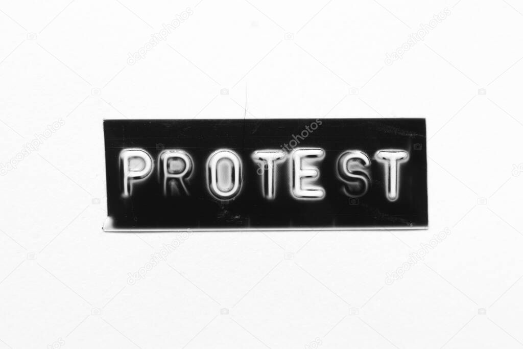 Black color banner that have embossed letter with word protest on white paper background