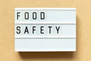 Ahşap arka planda kelime güvenliğiyle ışık kutusu