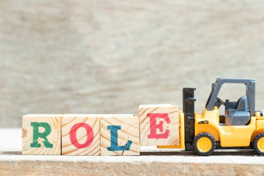 Oyuncak forklift harf engelini koru ve tahta arkaplanda sözcük rolünü tamamla
