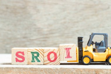 Oyuncak kaldırma harf engeli I kelime SROI tamamlamak için (Yatırım Toplumsal Dönüş) ahşap arka plan üzerine