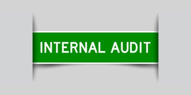 Inserted green color label sticker with word internal audit on gray background