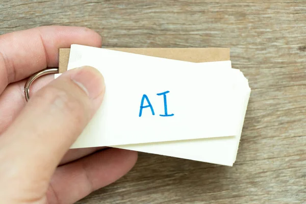 男人拿着印有笔迹字Ai 人工智能缩写 的闪存卡 背景为木头 — 图库照片