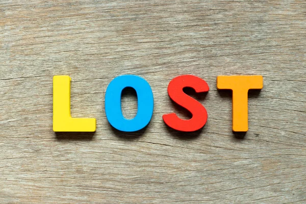 Ahşap arkaplanda kaybolan sözcükteki renk alfabesi harfi