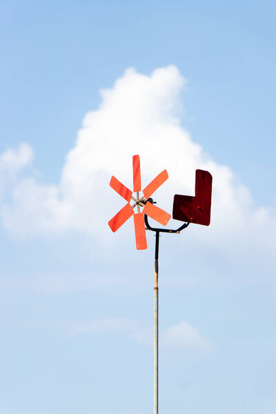 Red color windmill on blue sky background