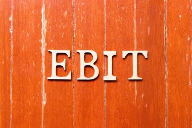 EBIT (Faiz Öncesi Kazançlar ve Vergilerin kısaltması) kelimesindeki alfabe harfi eski kırmızı tahta tabaka arka planında