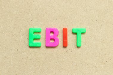 Tahta zemin üzerinde EBIT (Faiz Öncesi Kazançlar ve Vergilerin kısaltması) sözcüğüyle renk alfabesi harfi