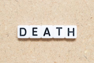 Tahta zemin üzerinde ölüm kelimesi olan beyaz kiremit alfabesi harfi