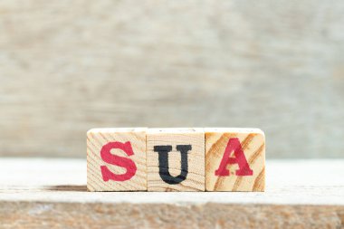 Tahta zemin üzerinde SUA (Tek kullanımlık hesabın kısaltması) sözcüğündeki alfabe harf bloğu